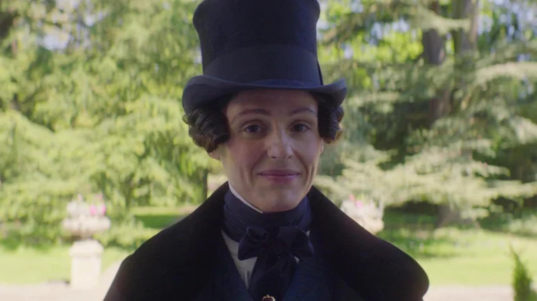 Anne Lister in top hat looking at camera