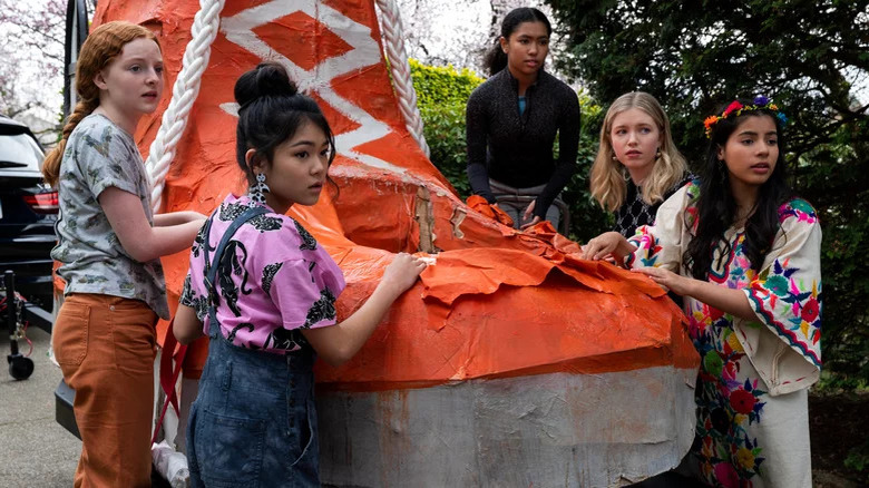 Girls around huge orange shoe 