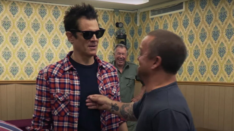 Wee Man holding his hand on Johnny Knoxville's chest