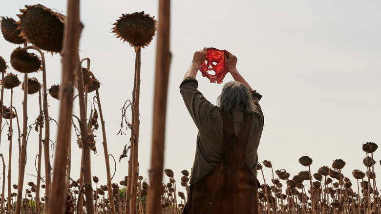 Leatherface holding up a face