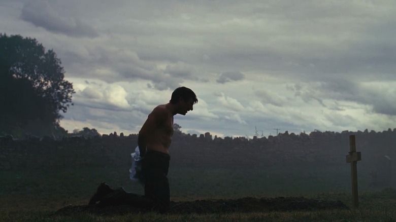 Oliver Quick kneeling on Felix's grave