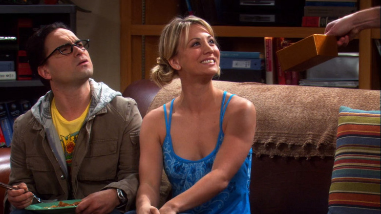 Leonard Hofstadter confused, Penny smiling at Sheldon Cooper handing her chocolate