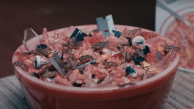 A bowl of cereal with razor blades and insects