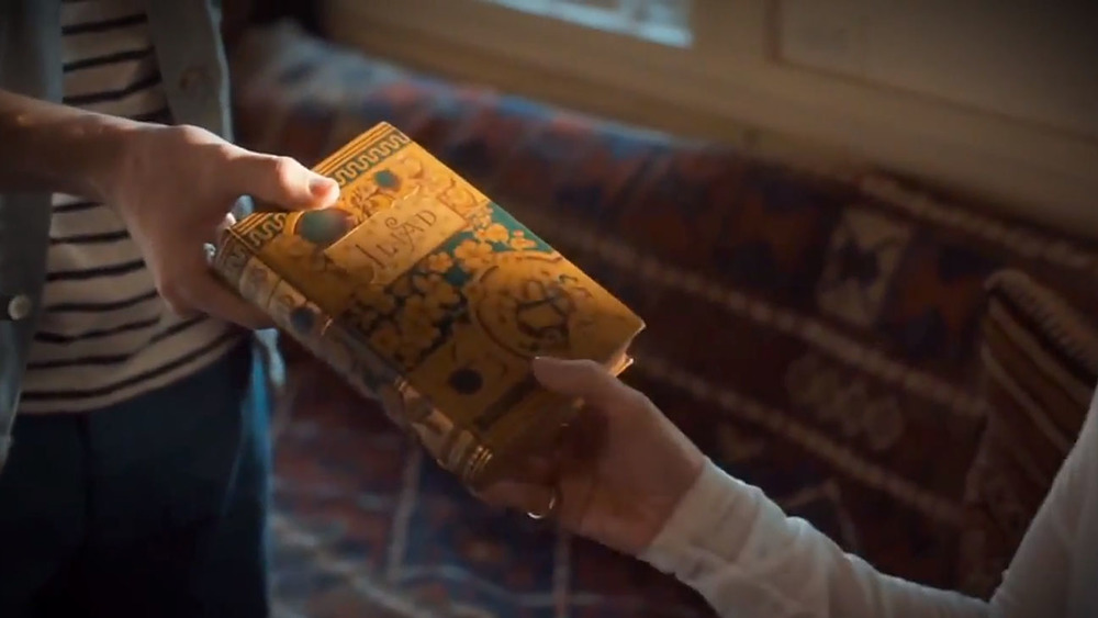 Boy handing woman antique book