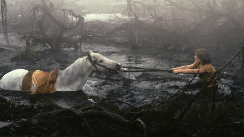 Noah Hathaway pulling horse through mud