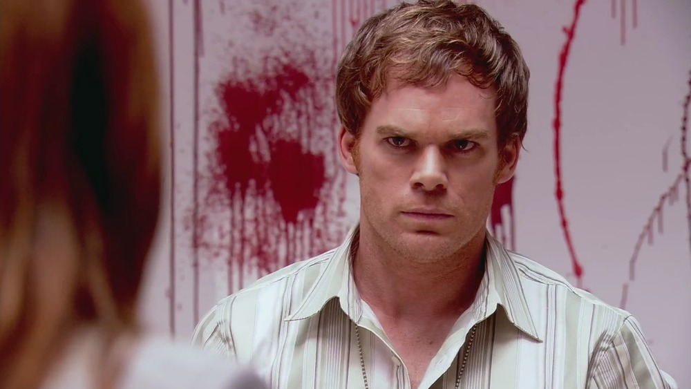 Michael C. Hall as Dexter Morgan, against a blood-splattered wall on Dexter