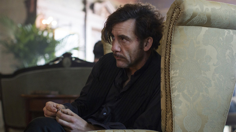 Clive Owen as Dr. Thackery, seated