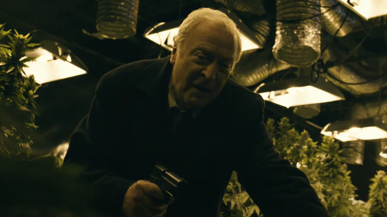 Michael Caine crouching with gun