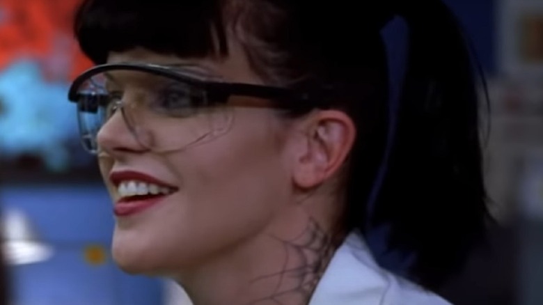 Abby in glasses with a web tattoo on neck