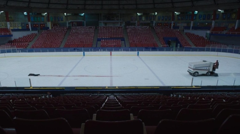 Bleeding man on hockey rink pursued by Zamboni