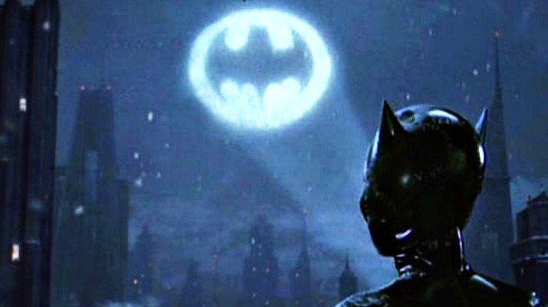 Catwoman watches the Bat-signal shining in the night