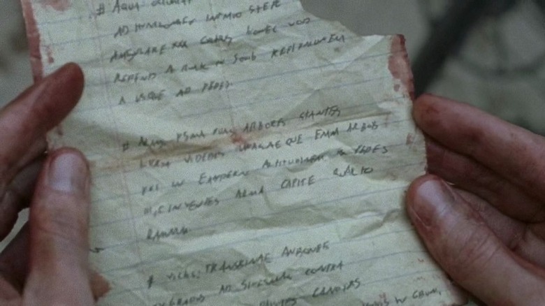 Spencer's hands holding bloodstained note