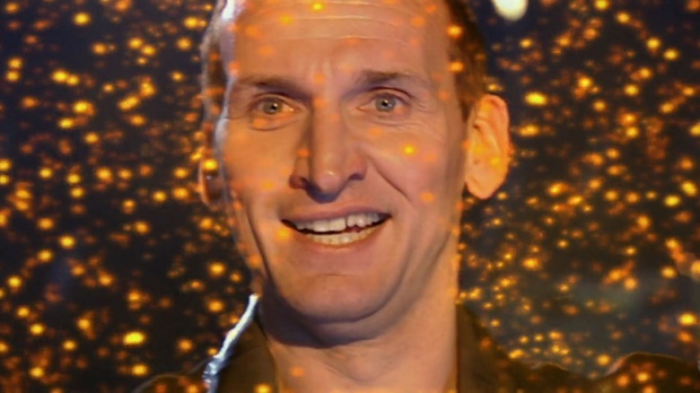 Ninth Doctor smiling among glowing nanobots