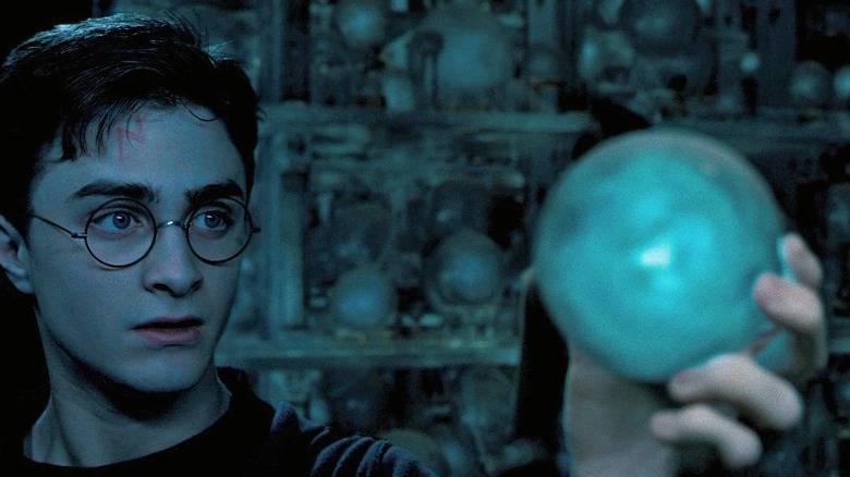 Harry Potter holding a prophecy in the department of mysteries