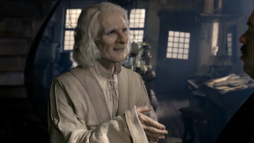 An aged Nicolas Flamel smiles