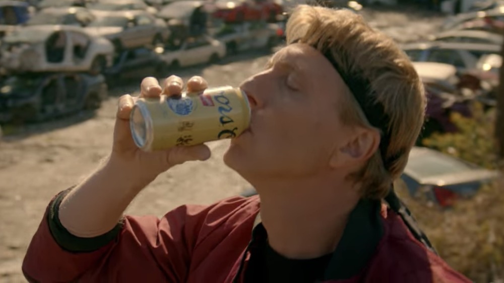 Johnny Lawrence drinking Coors Banquet