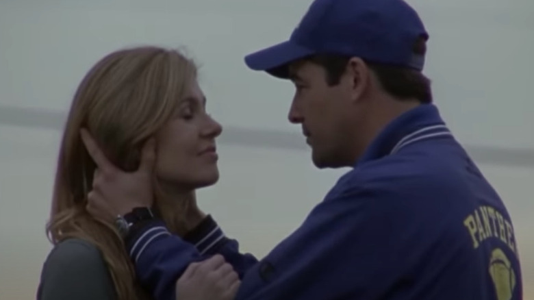 Coach and Tami hold each other on a field 