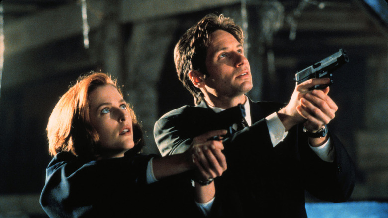Mulder and Scully aim pistols