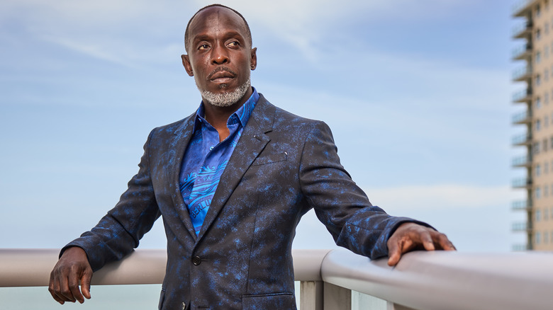 Michael K. Williams leans against a railing