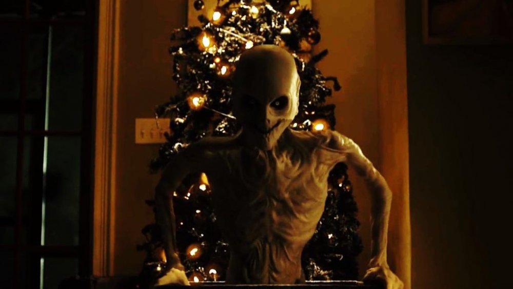 Skinny monster in front of a Christmas tree