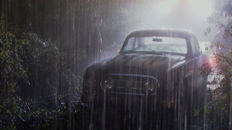 Frank looking at car in rain