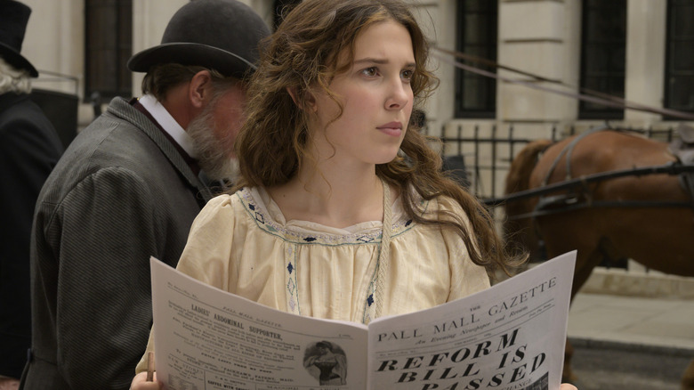 Enola holding a newspaper 