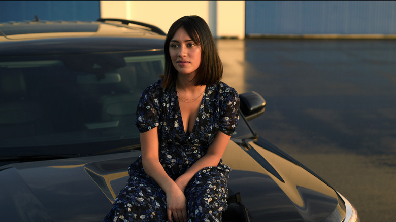 Rose Larkin sits on car