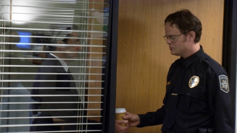 Dwight handing a coffee to Michael