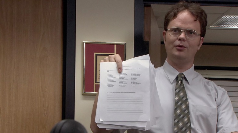 Dwight holding paper up