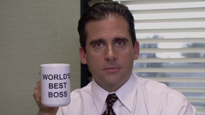 Michael Scott holds up cup