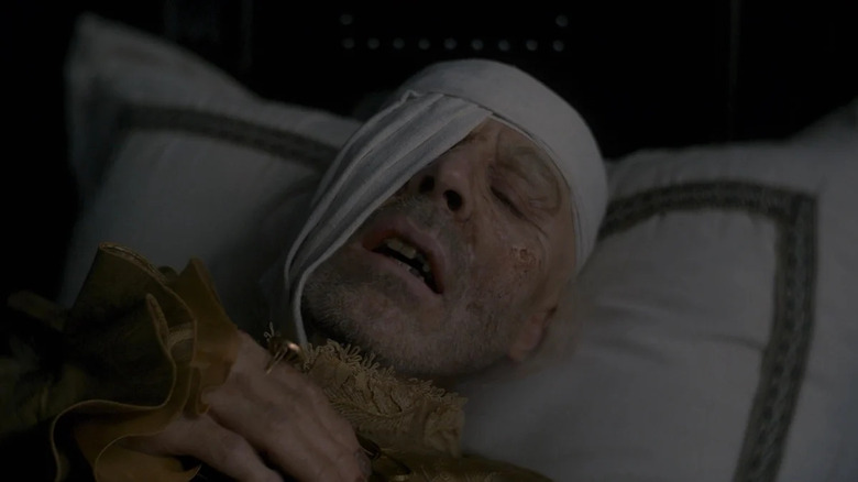 Viserys lays dying in his bed.