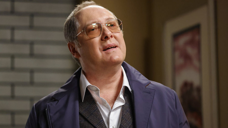 James Spader smirking as Red with glasses