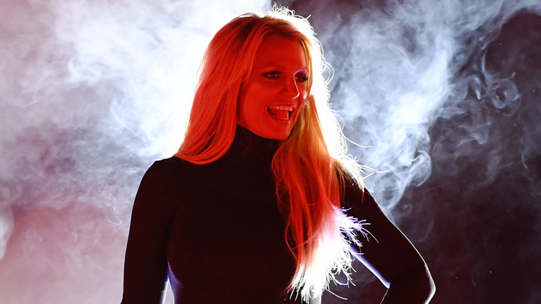 Britney performing on stage in front of smoke