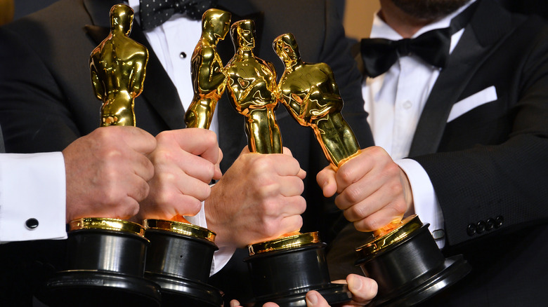 men holding Academy Awards