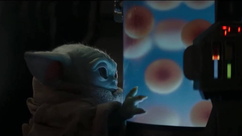 Baby Yoda gazes longingly at the jar of eggs in the Mandalorian