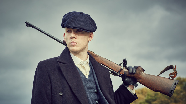 John Shelby holding a gun