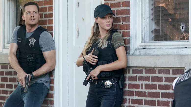 Hayley Upton and Jay Halstead holding guns