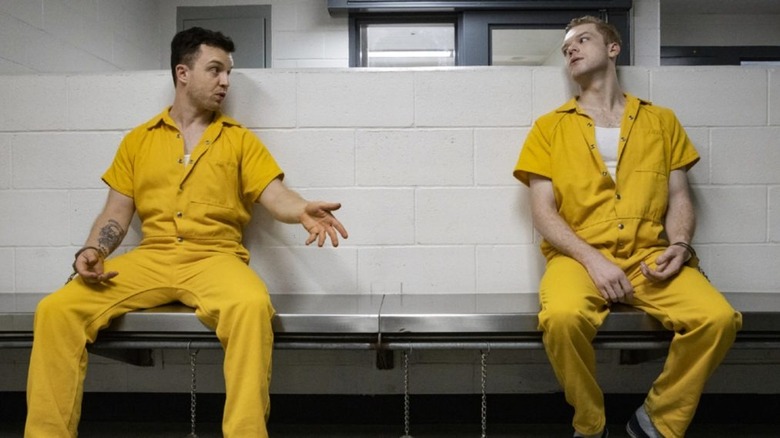 Mickey and Ian sitting on a bench in prison uniforms