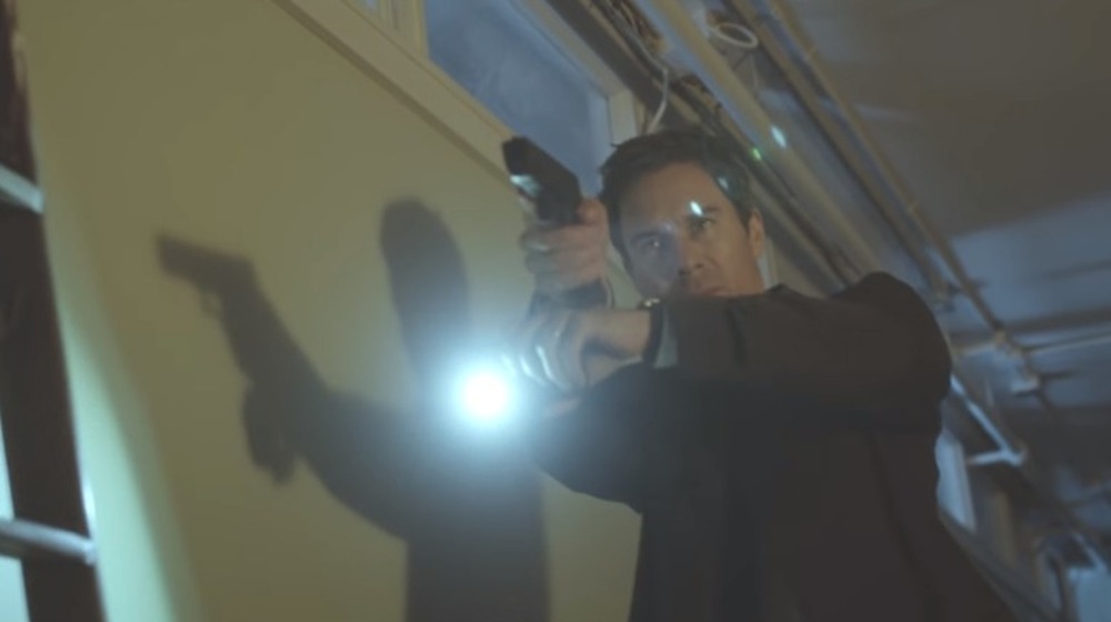 Travelers Eric McCormack holding gun