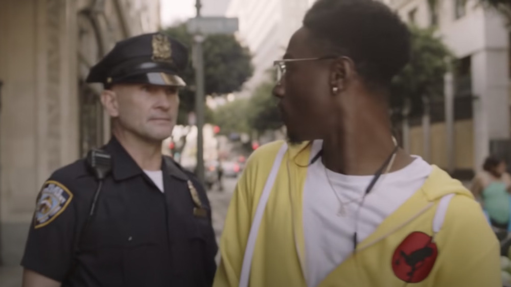 Joey Bada$$ and a police officer looking intense