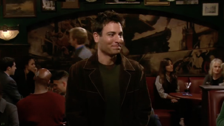 Ted Mosby smiling shyly with MacLaren's Pub in the background.