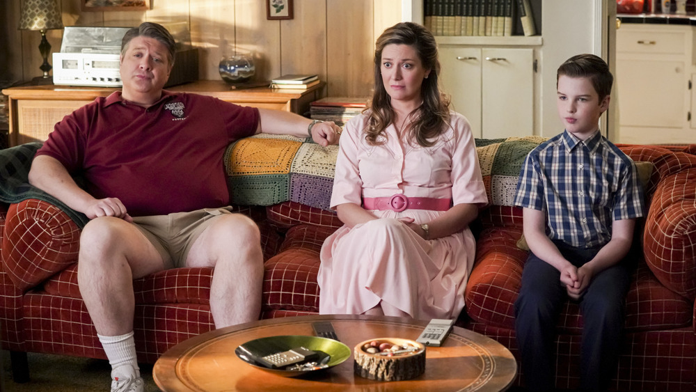 George Sr., Mary, and young Sheldon sit on the couch on Young Sheldon