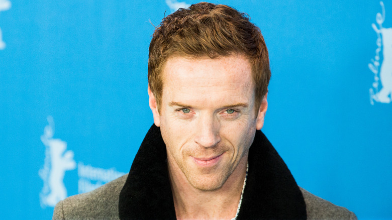 Damian Lewis smiles in front of photographers at red carpet