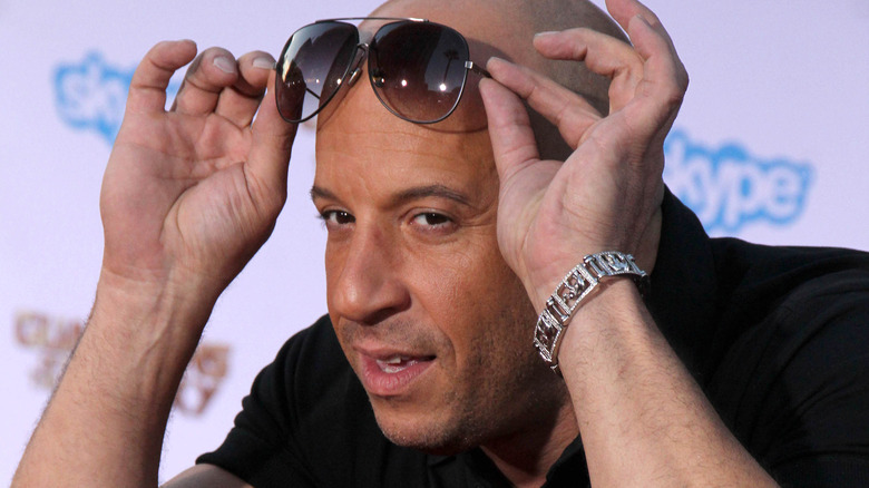 Dwayne Johnson placing sunglasses on his forehead