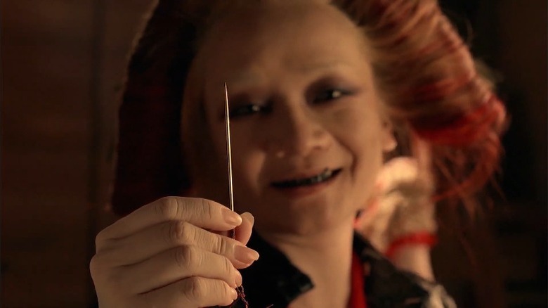 Woman holding needle and smiling