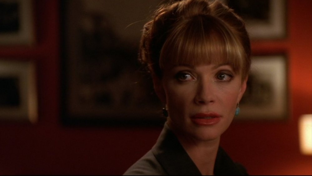 Lauren Holly as Jenny Shepard wears her hair up and looks over her shoulder in NCIS