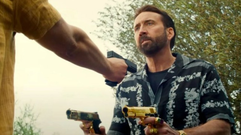 Nick Cage holding two pistols