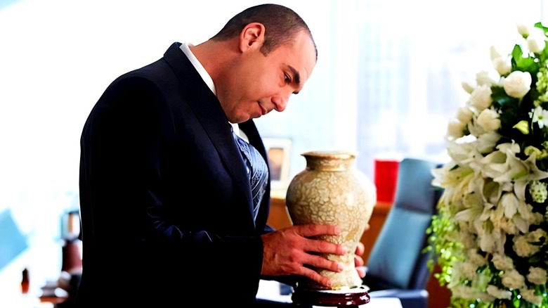 Louis Litt holding an urn