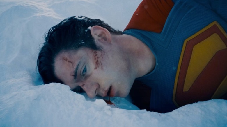 Superman lies in the snow with bloody face and mouth in 