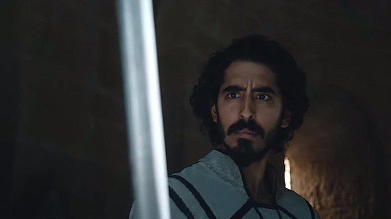 Dev Patel Sir Gawain staring at sword